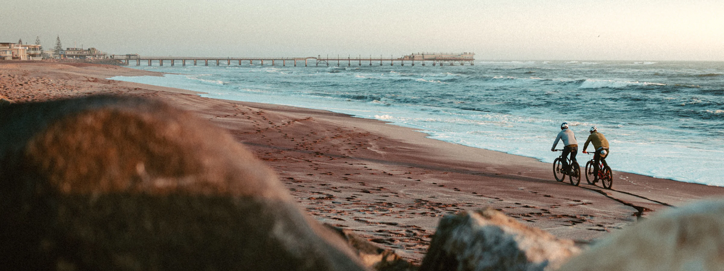 Zwei Radfahrer am Strand vor dem Meer